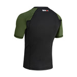 The SMAI Short Sleeve Rash Guard - Olive Green features black fabric on the back with dark green sleeves. "SMAI" is printed in white and red near the neckline.