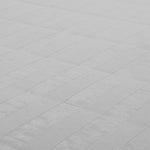 Close-up of the light grey SMAI Roll Out Workout Mat (Dollamur Flexi Roll), showing its white textured surface and subtle repeating checkered pattern, reflecting the mat's durable, high-quality material.