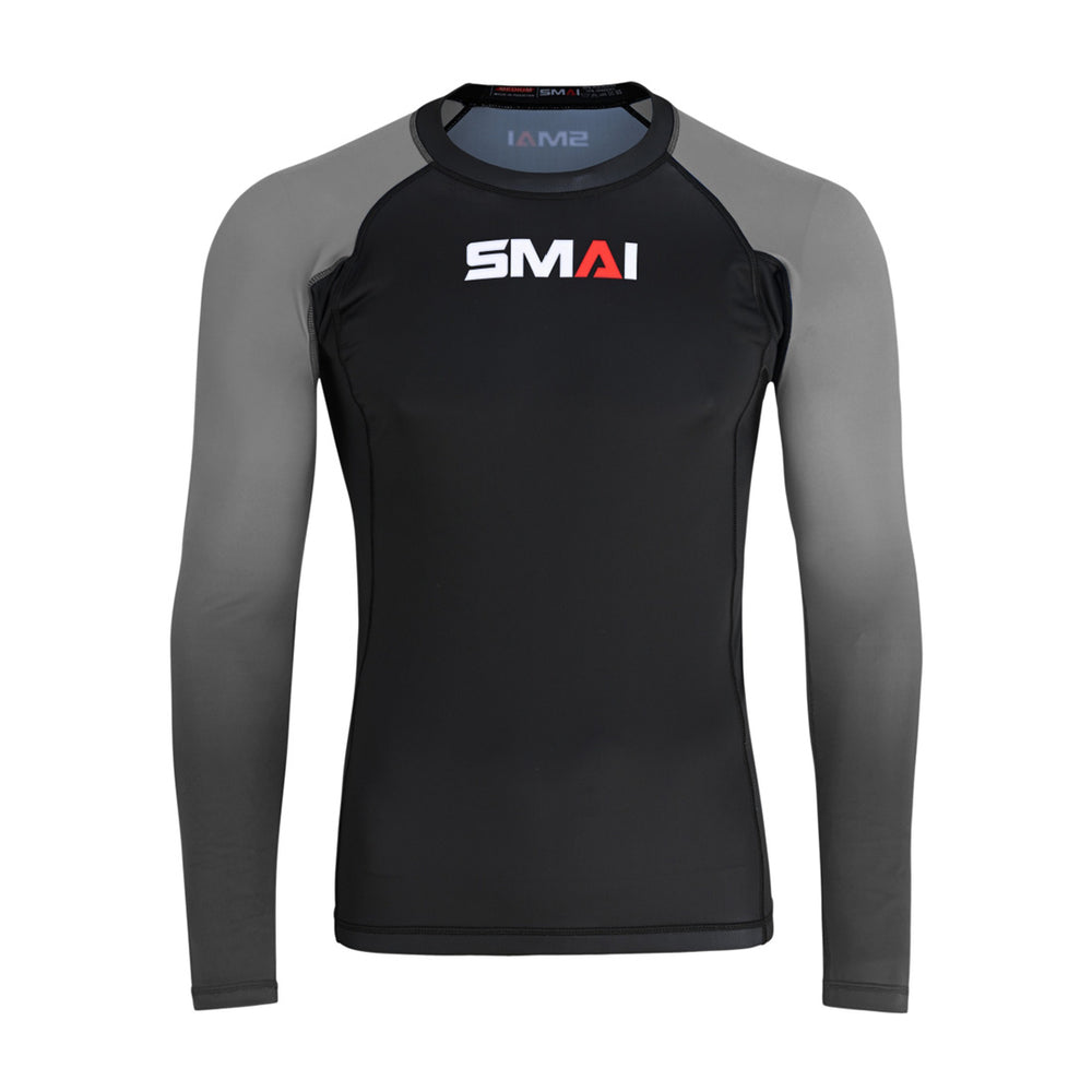 The SMAI Long Sleeve Rash Guard - Grey features a black body, grey sleeves, and the white and red "SMAI" chest logo—perfect for MMA or no-gi training. Displayed against a white background.