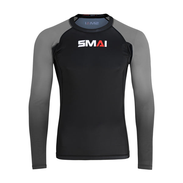The SMAI Long Sleeve Rash Guard - Grey features a black body, grey sleeves, and the white and red "SMAI" chest logo—perfect for MMA or no-gi training. Displayed against a white background.