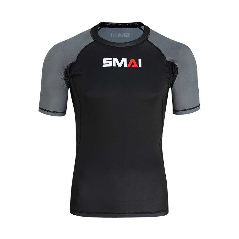 The SMAI Short Sleeve Rash Guard - Grey features a black front and back, grey sleeves, and a white/red "SMAI" chest logo—ideal as a BJJ rashguard for no-gi grappling.