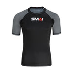 The SMAI Short Sleeve Rash Guard - Grey features a black front and back, grey sleeves, and a white/red "SMAI" chest logo—ideal as a BJJ rashguard for no-gi grappling.