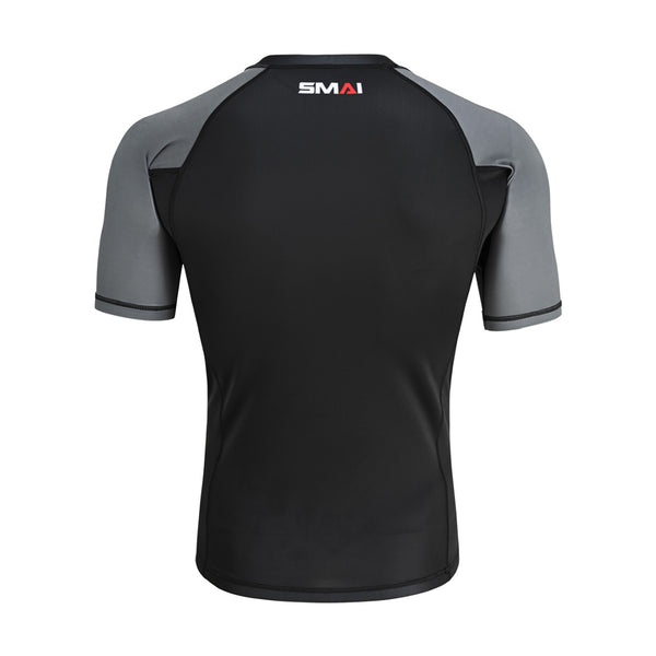 The SMAI Short Sleeve Rash Guard - Grey features gray sleeves and shoulders, a black body, and the "SMAI" logo near the back neckline—perfect for no-gi grappling or as a BJJ rashguard.
