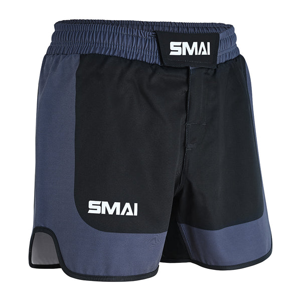 SMAI MMA Grappling Shorts - Black/Grey feature "SMAI" in white on the waistband and left leg, a Velcro waistband, side slits for movement, and a stretch fabric gusset for flexibility.