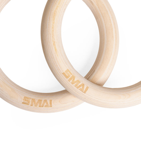 The SMAI Wooden Gym Rings with Numbered Straps feature two light wood rings engraved with "SMAI," overlapping on a white background. The set includes adjustable numbered straps and an aluminum clamp for secure installation.