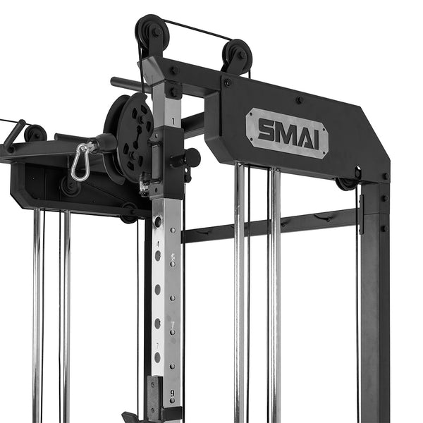 Close-up of the upper section of the SMAI All-In-One Home Gym Trainer - Plate Loaded (Demo Stock), featuring black metal, pulleys, weight adjustment numbers, and a metal plate with the "SMAI" logo.