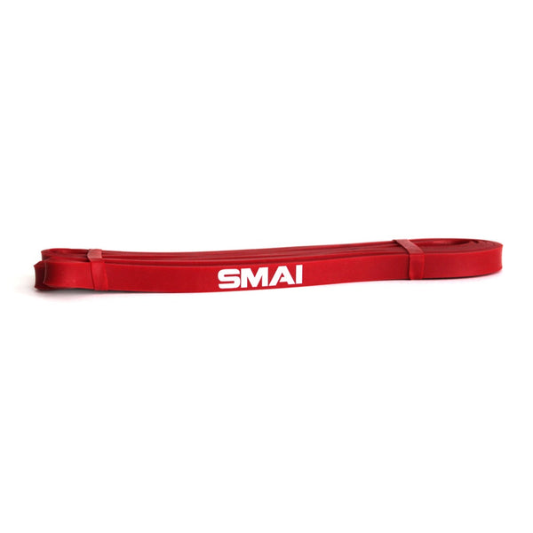 A red resistance band from the "Light Recovery & Stretch Pack" by SMAI is displayed on a pristine white background, ideal for glute toning and versatile workouts.