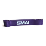 A rubber resistance band from the SMAI Firm Recovery & Stretch Pack, in an eye-catching purple shade, is coiled in a flat loop against a crisp white background—perfect for toning glutes.