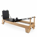 The SMAI Pilates - Classical Maple Reformer features black padding, footbar, adjustable ropes, and shoulder blocks—ideal Pilates equipment for studios to support a range of strength and flexibility exercises.