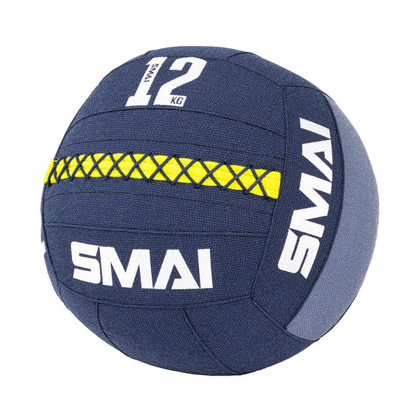 The SMAI Wall Balls - Hybrid Range in navy blue features a yellow stitched stripe, "12 KG" in white on the top panel, durable aramid fibre, and prominent "SMAI" branding—perfect for hybrid strength training.