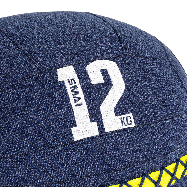 Close-up of a SMAI Wall Balls - Hybrid Range in navy blue, showing white "SMAI 12 KG" text. Its textured surface and yellow mesh detail highlight premium design—ideal for hybrid strength training.