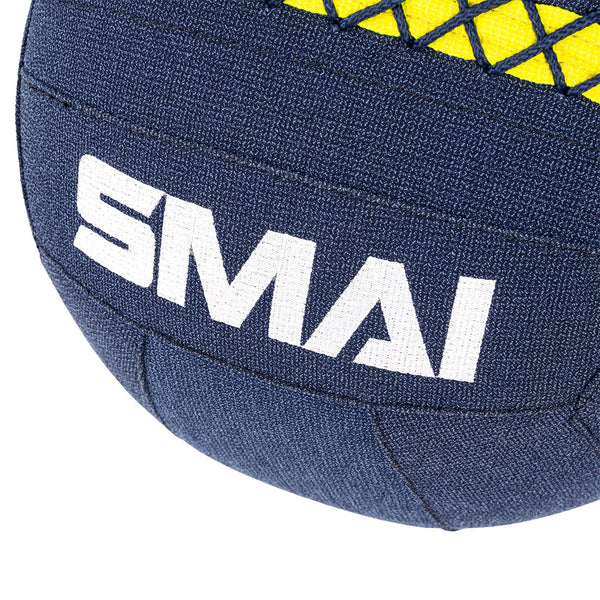 Close-up of a dark blue SMAI Wall Balls - Hybrid Range with stitched panels, "SMAI" in white text, and a yellow-black crisscross pattern on top—designed for hybrid strength training.