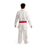 A person wearing the SMAI WKF Reversible Karate Uniform - 6oz Premium Kumite Gi - Inazuma RX stands facing away, with a red belt tied around their waist against a plain white background.
