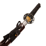 A close-up of the SMAI High Carbon Steel Katana - Crimson Eclipse shows its ornate tsuba, wrapped handle with tied cord, and matching scabbard beside the striking partially unsheathed Damascus folded steel blade.