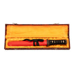 The SMAI Damascus Red Tiger Tanto features a full tang red Damascus blade, black and gold handle, and comes sheathed in an ornate presentation box with yellow lining and a patterned exterior.