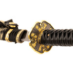 Close-up of the SMAI Forged Carbon Steel Katana - Dark Emperor, highlighting its gold and black hand guard, black wrapped full tang handle, and partially unsheathed striking blade.