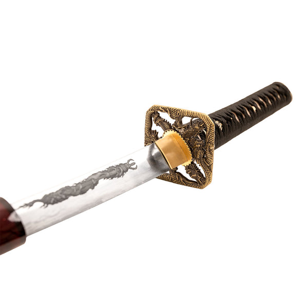 A close-up of the SMAI Katana - Blood Dragon featuring a detailed gold handguard, black-wrapped handle, and partially visible blade with a dragon engraving, highlighting its stunning clay-forged Hamon.