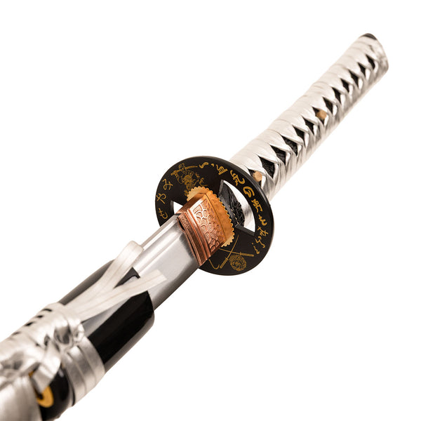 A close-up of the SMAI Display Carbon Katana - Black Dragon Rose Tip shows its carbon steel blade, ornate handguard with golden Japanese characters and dragon motif, and a white and silver-wrapped handle.