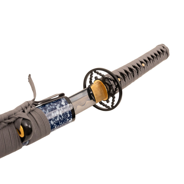 A close-up of the SMAI Medium Carbon Blue Katana - Dark Atlantis, a full tang katana with a black and gold handguard, gray-wrapped handle, patterned blue and white scabbard, and its medium carbon steel blade partially drawn.