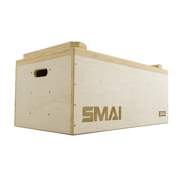 The SMAI Jerk Blocks 2.0 (Pair) are rectangular wooden boxes with cutout handles, marked "38CM" on one corner, ideal for plyometric exercise or fitness training. The "SMAI" logo is featured on the side.