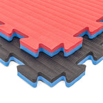 The SMAI Jigsaw Mat - 2cm - Factory Seconds features interlocking red and black EVA mats with blue cores, textured surfaces, zigzag edges for easy fitting, and minor cosmetic imperfections—ideal as gym tiles.