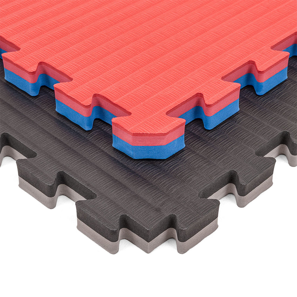Two SMAI Jigsaw Mat - 3cm - Factory Seconds with cosmetic imperfections are stacked diagonally: the top shows red with a blue and white core, the bottom is black with a gray layer. Both mats feature textured surfaces.