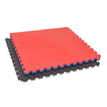 Two SMAI Jigsaw Mats - 3cm - Factory Seconds with cosmetic imperfections are stacked, red on top and black below. Featuring puzzle edges and textured surfaces, they're ideal gym tiles for flooring in gyms or play areas.