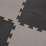 Close-up of SMAI Jigsaw Mat - 3cm (Factory Seconds) showing textured interlocking tiles in alternating light and dark gray, with puzzle-like edges and "SMAI" embossed on one piece. These mats have minor cosmetic imperfections.
