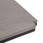 Close-up of two SMAI Jigsaw Mats (3cm, Factory Seconds) with cosmetic imperfections, featuring interlocking textured gray surfaces and puzzle-like edges, stacked together.