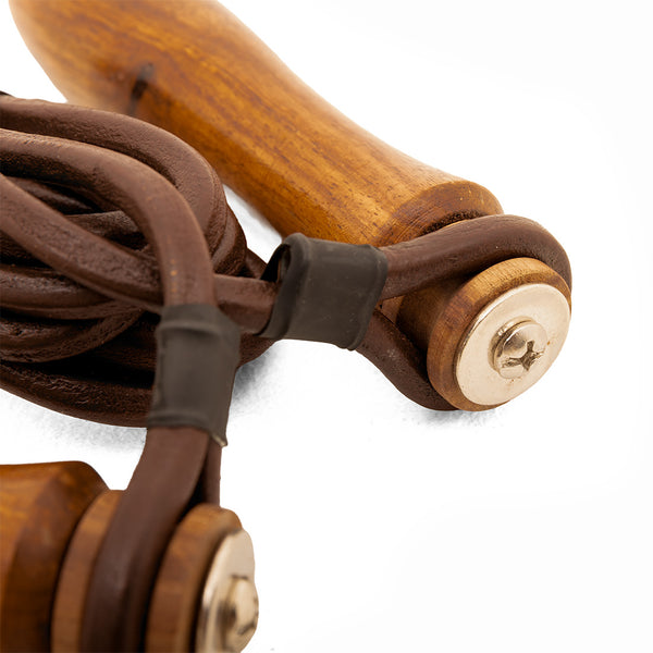 Close-up of the SMAI Leather Skipping Rope - Wooden Handles, featuring wooden grips, metal end caps, and black plastic fasteners in a classic design against a white background.
