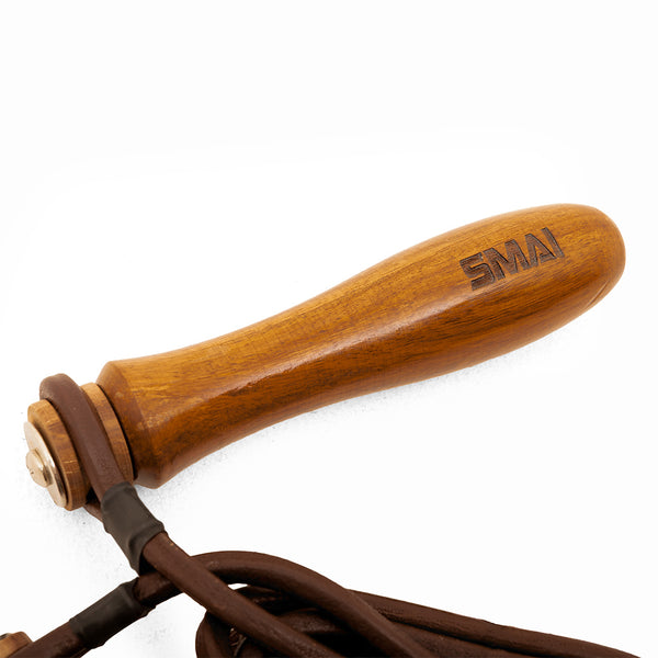 A close-up of SMAI Leather Skipping Rope - Wooden Handles, showing the engraved wooden handles and brown leather rope against a white background.
