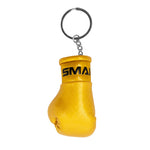 The SMAI Boxing Glove Keyring features a small gold glove with "SMAI" in black near the wrist, attached to a metal keyring by a short chain—an ideal boxing gift for fans.