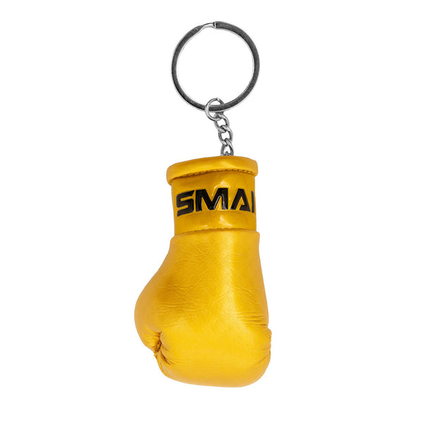 The SMAI Boxing Glove Keyring features a small gold glove with "SMAI" in black near the wrist, attached to a metal keyring by a short chain—an ideal boxing gift for fans.