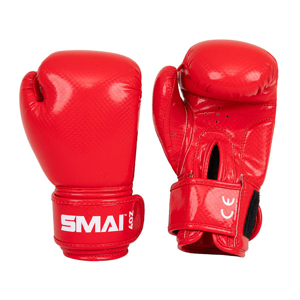 Two vibrant red Essentials Kids Boxing Gloves by SMAI—one displays the branded front, the other shows the palm side with a Velcro strap and ventilation holes—perfect for young boxers.