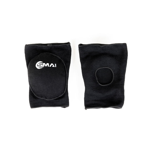 Two black SMAI Padded Knee Guards (Extra Small) are shown flat on a white background. One displays the SMAI logo and padded oval front; the other shows a circular opening at the back, ideal for judo and martial arts.