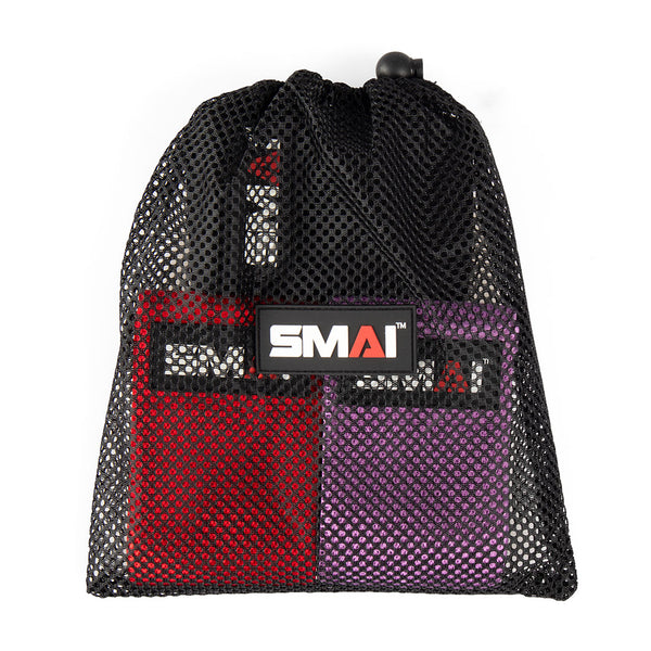 A black mesh drawstring bag, showcasing a sleek black-and-white logo with a distinctive red triangle on the letter "A", contains vibrant red and purple knitted mini resistance bands. This set of three is perfect for glute activation exercises.