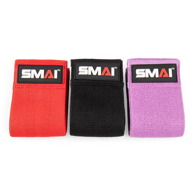 Three knitted mini resistance bands in red, black, and purple, each featuring the "No Sync To Channel Engine" logo on a rectangular patch. Ideal for glute activation exercises, these booty bands are neatly rolled and arranged side by side on a pristine white background.