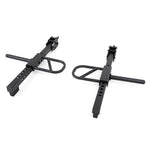 The X-Frame - Jammer Arms by No Sync To Channel Engine are designed with a strong black metal construction, featuring adjustable bolt holes similar to those found in SMAI Jammer Arms. Each arm includes a looped handle for securing bikes. Displayed against a white background, their robust structure is highlighted.