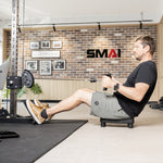 A man sits on a SMAI Low Row Seat Floor using a cable rowing machine.