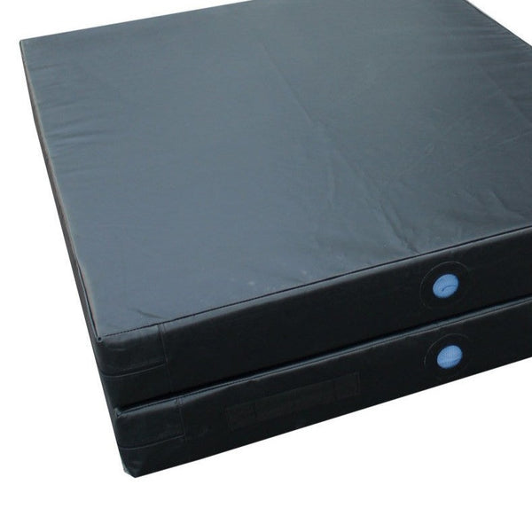 This is a pair of black SMAI Gymnastics Landing Crash Mats in a stack, featuring smooth surfaces and blue circular patches on the sides. These thick, foldable, rectangular mats are designed for safety during gymnastic exercises or physical activities.