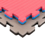 Close-up of SMAI Jigsaw EVA Mat - Value Range - 2cm, featuring gray and pink interlocking pieces with a blue core layer. These textured, puzzle-edged mats are ideal as gym flooring or versatile jigsaw mats for various spaces.