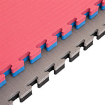 Close-up of SMAI Jigsaw EVA Mat - Value Range - 4cm mats: pink with blue edges on top, gray with black edges below. These textured puzzle mats easily interlock and are ideal for gym flooring.