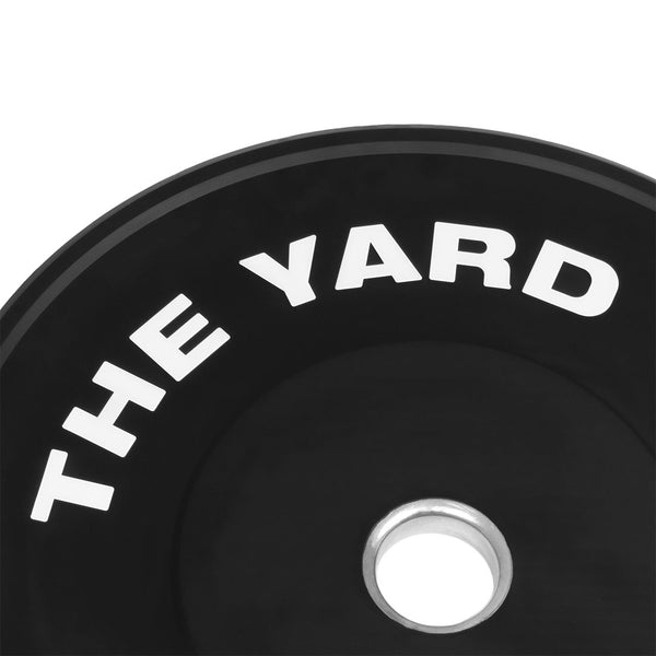 Close-up of SMAI's The Yard - HD Bumper Plates (Pair) - 20kg, crafted from high-density virgin rubber with "THE YARD" in bold white near the edge and a silver center hole—ideal for any home gym.