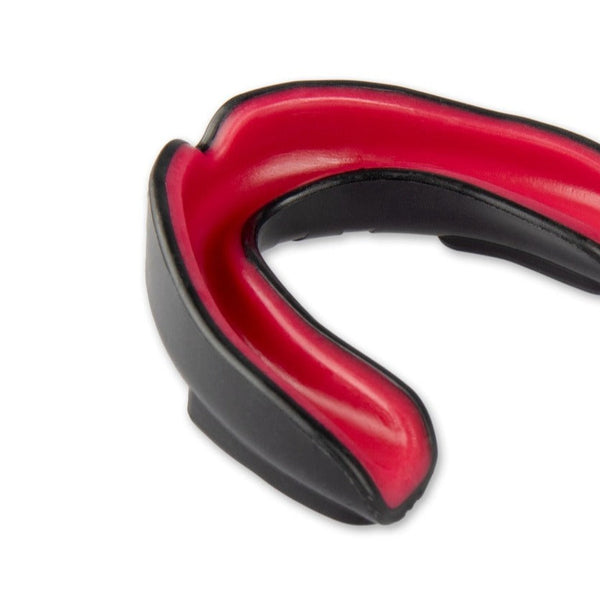 Close-up of the SMAI Mouth Guard Senior - Gel, in black and red, designed to protect teeth during physical activities. This sports mouthguard features a U-shape with a thick outer layer for cushioning and a gel-fit liner for enhanced comfort.