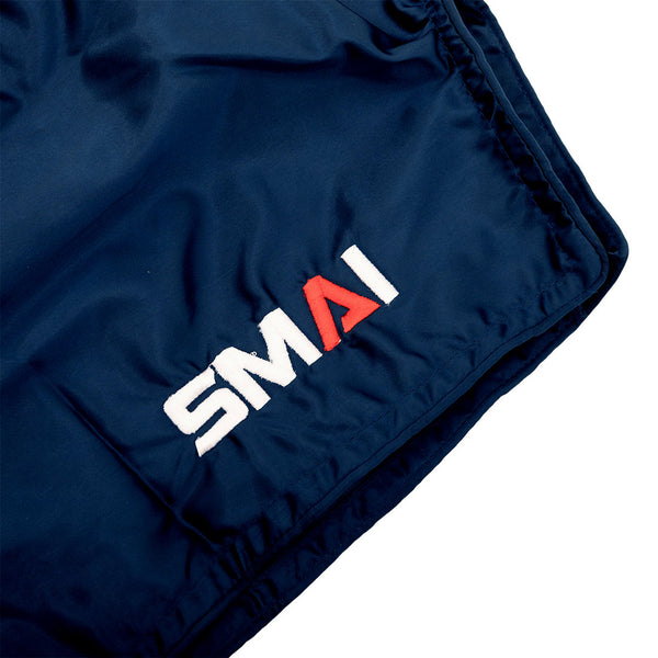 Close-up of SMAI Muay Thai Shorts - Navy, featuring “SMAI” embroidered on the front in white letters except for the red “A.”.