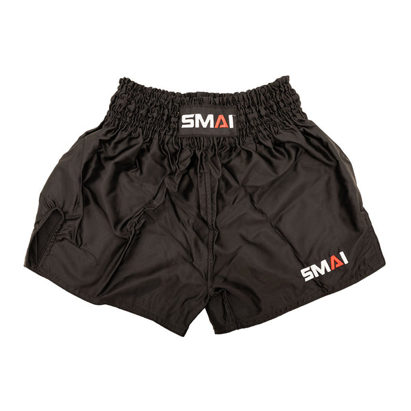 The SMAI Muay Thai Shorts - Black are unisex satin polyester shorts with an elastic waistband and "SMAI" branding on the waistband and lower left leg.