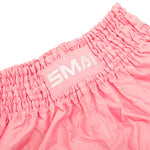 Close-up of the elastic waistband on the SMAI Muay Thai Shorts - Pink, featuring a white patch with embroidered "SMAI" lettering.