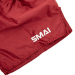 SMAI Muay Thai Shorts - Red: Unisex shorts with a white "SMAI" logo on the bottom hem, made from smooth, quick-dry satin with a slightly wrinkled look.