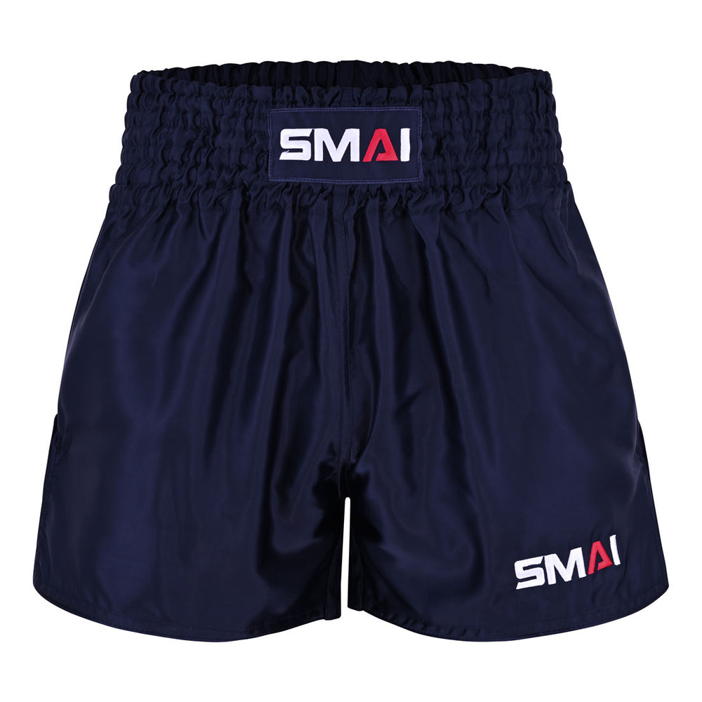 The SMAI Muay Thai Shorts - Navy feature a wide elastic waistband and display the “SMAI” logo in white and red on both the waistband and lower left leg. These unisex shorts are crafted for optimal comfort and performance.