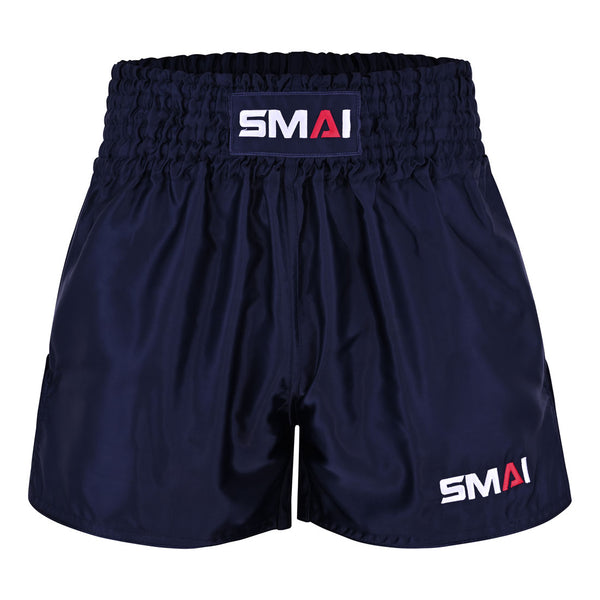 The SMAI Muay Thai Shorts - Navy feature a wide elastic waistband and display the “SMAI” logo in white and red on both the waistband and lower left leg. These unisex shorts are crafted for optimal comfort and performance.
